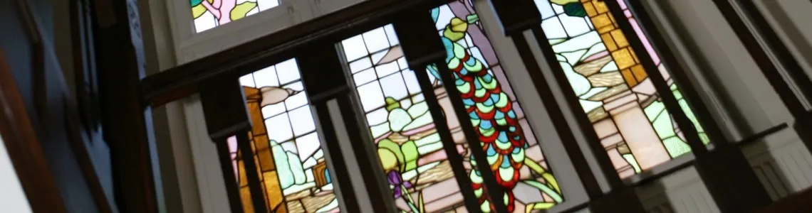 Jugendstil glas-in-lood met pauwmotief in het trappenhuis van Residentie Prinses Juliana